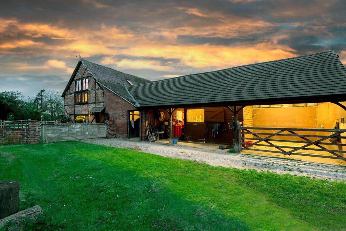 The barn and farmyard at sunset with orange sky