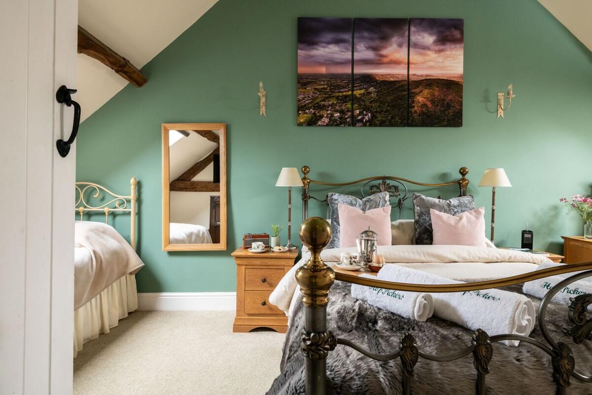 Bedroom with iron bedstead and sage green walls