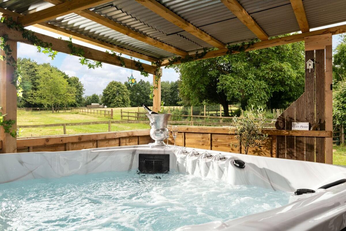 Hot tub under a roof with a view over fields