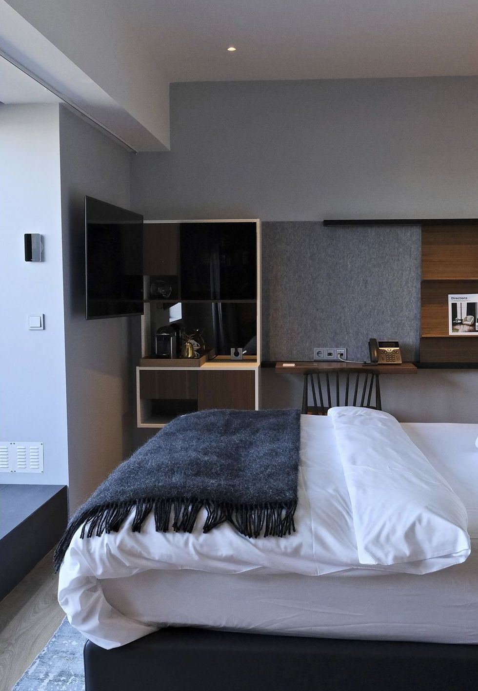 The Junior Suite with a large bed and wool throw
