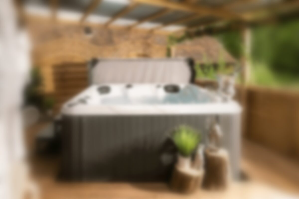 Soft-focus photo of a hot tub under a covered wooden deck