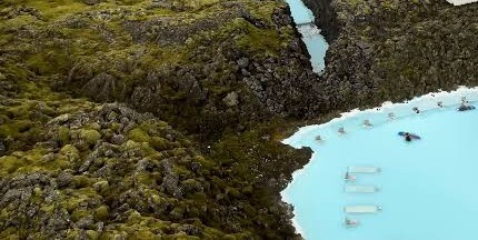 Moss-covered lava beside bright blue water