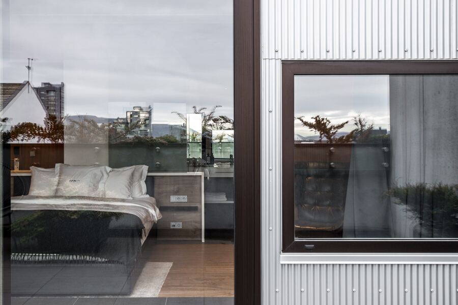 Junior Suite bed beside the glass balcony doors