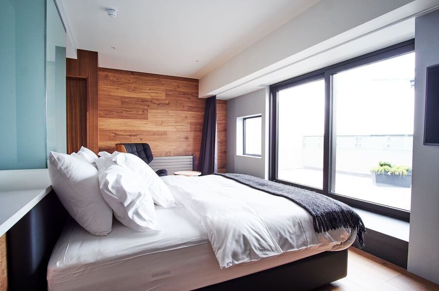 Junior Suite bedroom with big windows over the rooftops