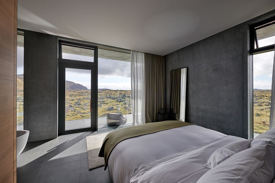Looking from the bed through floor-to-ceiling windows