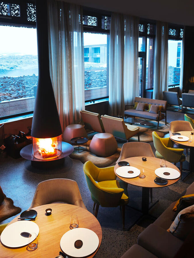 Moss restaurant with a hanging fireplace and lagoon views